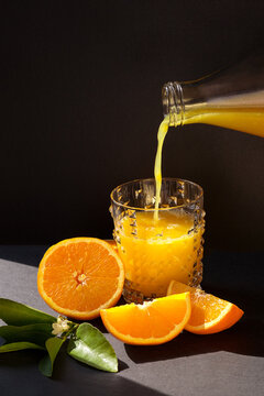 Orange juice pouring in the glass from bottle