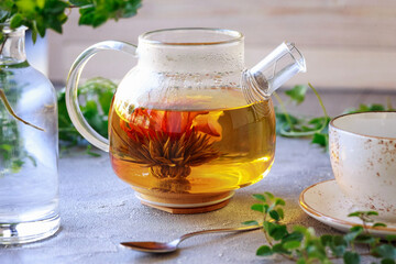 Bright photo with teapot with blooming tea
