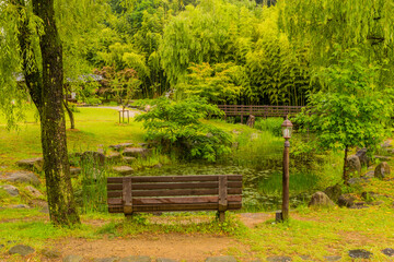 Wooden park bench next to pond.