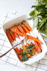Healthy Homemade Roasted Carrots with yougurt sause, vegan, vegatarian homemade food, fresh basil. White background