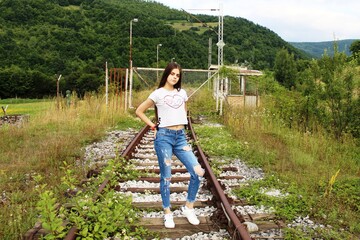 Long haired teenage girl pose on old rusty railway