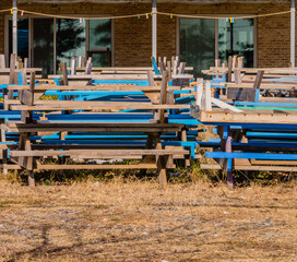 Fototapeta na wymiar Blue and white wooden picnic table stacks