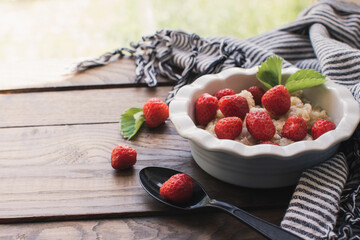 Breakfast. Tasty oatmeal with berries. Healthy breakfast ingredients. Oat granola in bowl with strawberry and mint. Granola for breakfast with berries.
