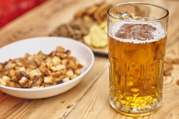 A glass of beer and different snacks on the table. Celebrating international beer day or Octoberfest. Drinking beer after a hard working day or week