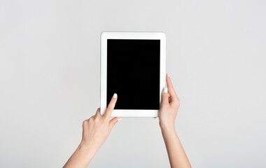 Female hand touching blank screen of tablet computer on white background, mockup for your design