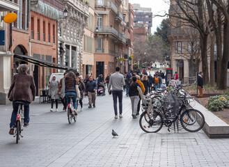 Fototapeta na wymiar Street of the old european city with walking and cycling people
