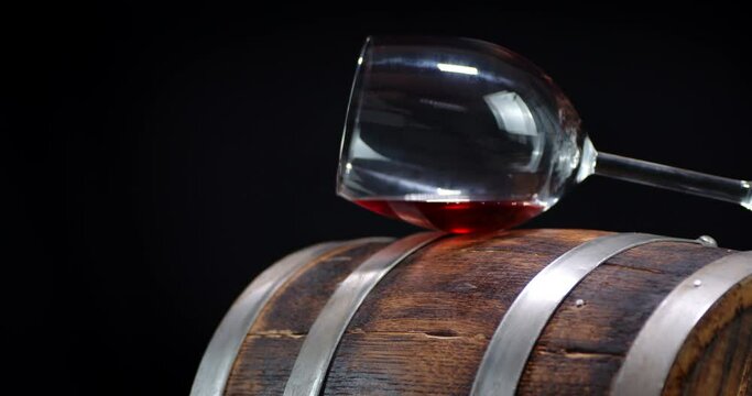 The wine glass on the barrel slowly rotates.