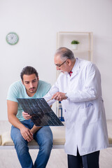 Fototapeta premium Young back injured man visiting experienced male doctor