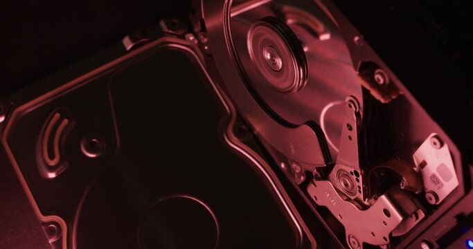 Hard Drive spinning under red light, open Hard Disk enclosure showing inner side