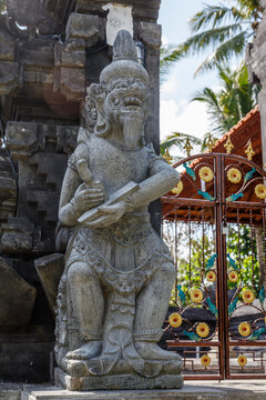 Statue of Sang Suratma god at Balinese Hindu Pura Dalem (Temple of the Dead) entrance, Gianyar, Bali Island, Indonesia. Vertical image.