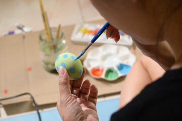people using green and blue watercolor painting on easter egg