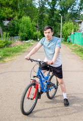 young man rides a bicycle in the countryside