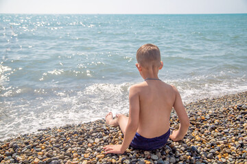 Fototapeta na wymiar teenager ashore on a sunny summer day rear view