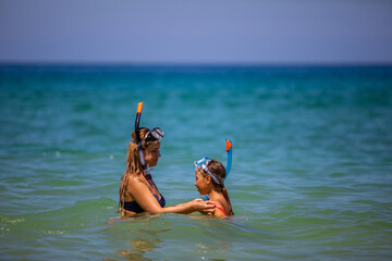 Mom with a daughter in masks for snorkeling