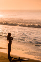 young woman training in the morning before surfing on a tropical beach. 
sunrise on the beach