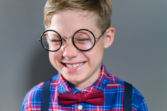 Portrait of cute prodigy schoolboy in eyeglasses on lesson