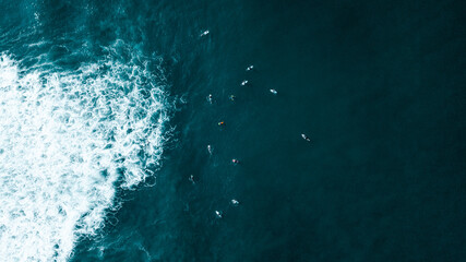 Breathtaking Aerial view over the blue ocean, crushing wave and surfers from high above the sea. Dreamy seascape. Ocean background. Drone shot for interior