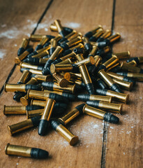 .22 ammunition in pile on a board surrounded by powder