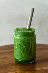 Green apple spinach smoothie in glass jar with eco-friendly reusable metal straw. Healthy summer refreshment drink. Safe for environment. Copy space