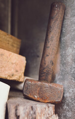 Old used Rusty Hammer leaning again steel sitting on a timber ledge