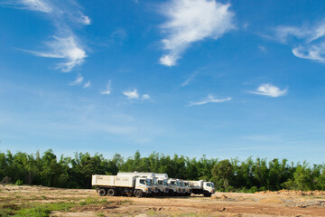 Many white trucks on a blue sky background.