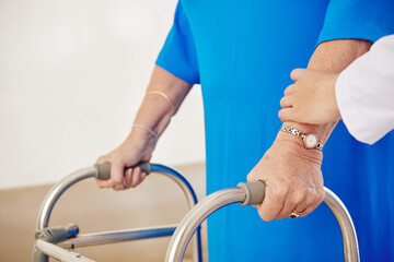 Close-up image of senior woman moving with walker for first time after surgery with support of nurse