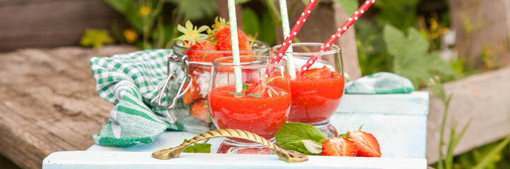 strawberry cocktail in glasses on a tray in a garden, selective focus