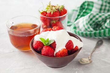 strawberry with sour cream in a bowl on a table, selective focus
