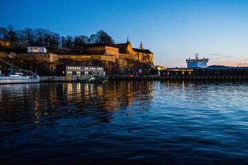Fototapeta na wymiar Akershus Castle and Fortress, Oslo, Norway. A wonderful picture of the fortress at sunset from the ocean. The foreboding fortress walls are captured as well as the timeless beauty of the castle.