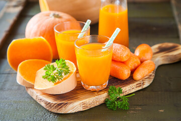 pumpkin carrot juice in a glass on a table, selective focus