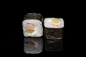 Sushi and rolls on a black mirrored background.