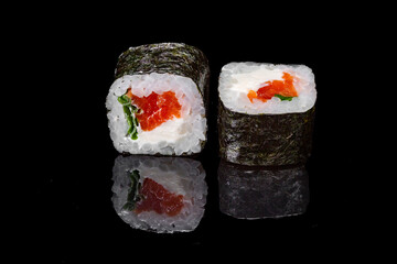 Sushi and rolls on a black mirrored background.