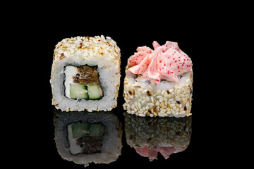 Sushi and rolls on a black mirrored background.