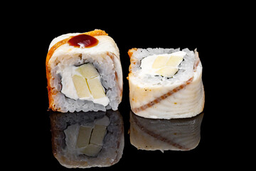 Sushi and rolls on a black mirrored background.