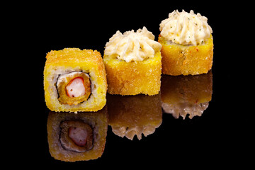 Sushi and rolls on a black mirrored background.