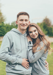 
Girl hugs a guy. A girl and a guy in identical sweatshirts at the stadium