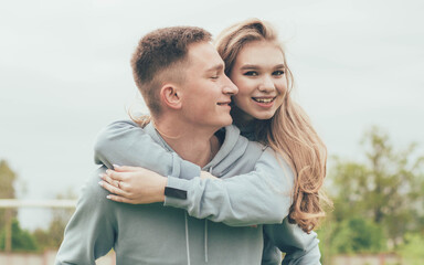 Fototapeta premium A girl sits on a guy's back,