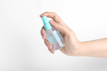 Woman holding antiseptic spray on white background, closeup