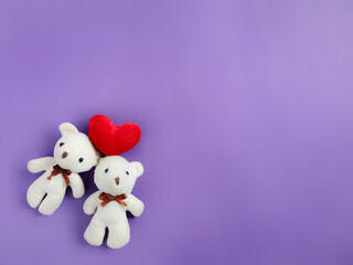 Friendship Celebration Concept -Teddies with red heart shaped in purple background. Stock photo