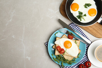 Flat lay composition with tasty fried eggs on light grey marble table. Space for text