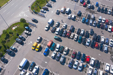 Plenty of cars in the packed parking lot in straight rows from a bird's-eye view