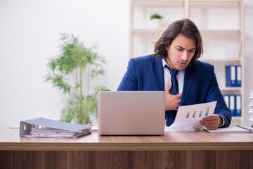Young male employee unhappy with excessive work