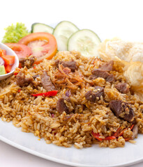 Fried rice. Meat fried rice. Beef fried rice. Lamb fried rice. Fried rice with soy sauce and seasonings, meat, decorated with pickles, tomatoes, cucumbers, chips.