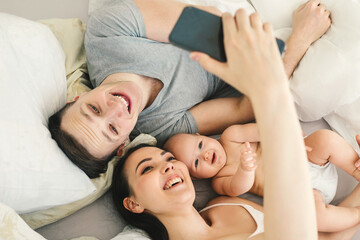 Happy young father, mother and cute baby