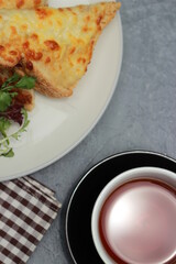 Quesadilla bread on a plate with healthy vegetables and a cup of tea in a glass. Top view
