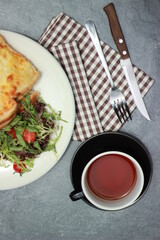 Quesadilla bread on a plate with healthy vegetables and a cup of tea in a glass. Top view