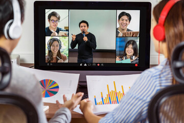 Rear view of Asian partner working and online meeting via video conference with speaker and...