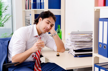 Fototapeta premium Young businessman employee drinking in the office