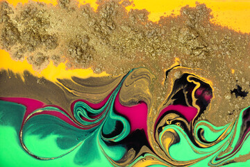 Colorful bright abstract ink pattern with golden powder scattering.