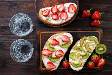 Tasty homemade fruit bruschetta with chopped strawberries, ricotta and kiwi, healthy and delicious dessert, snacks, antipasti